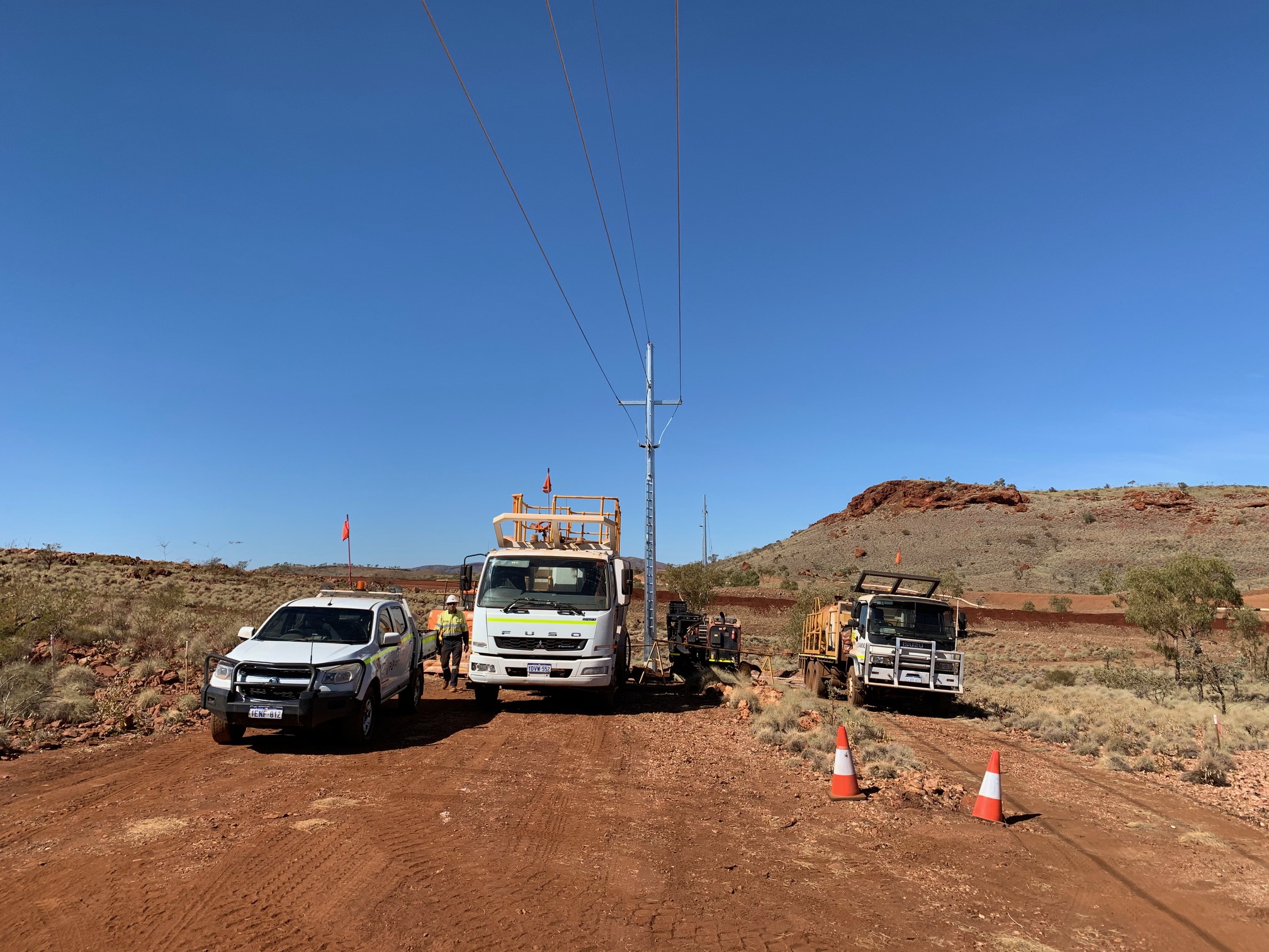 Workers assessing power lines in outback setting